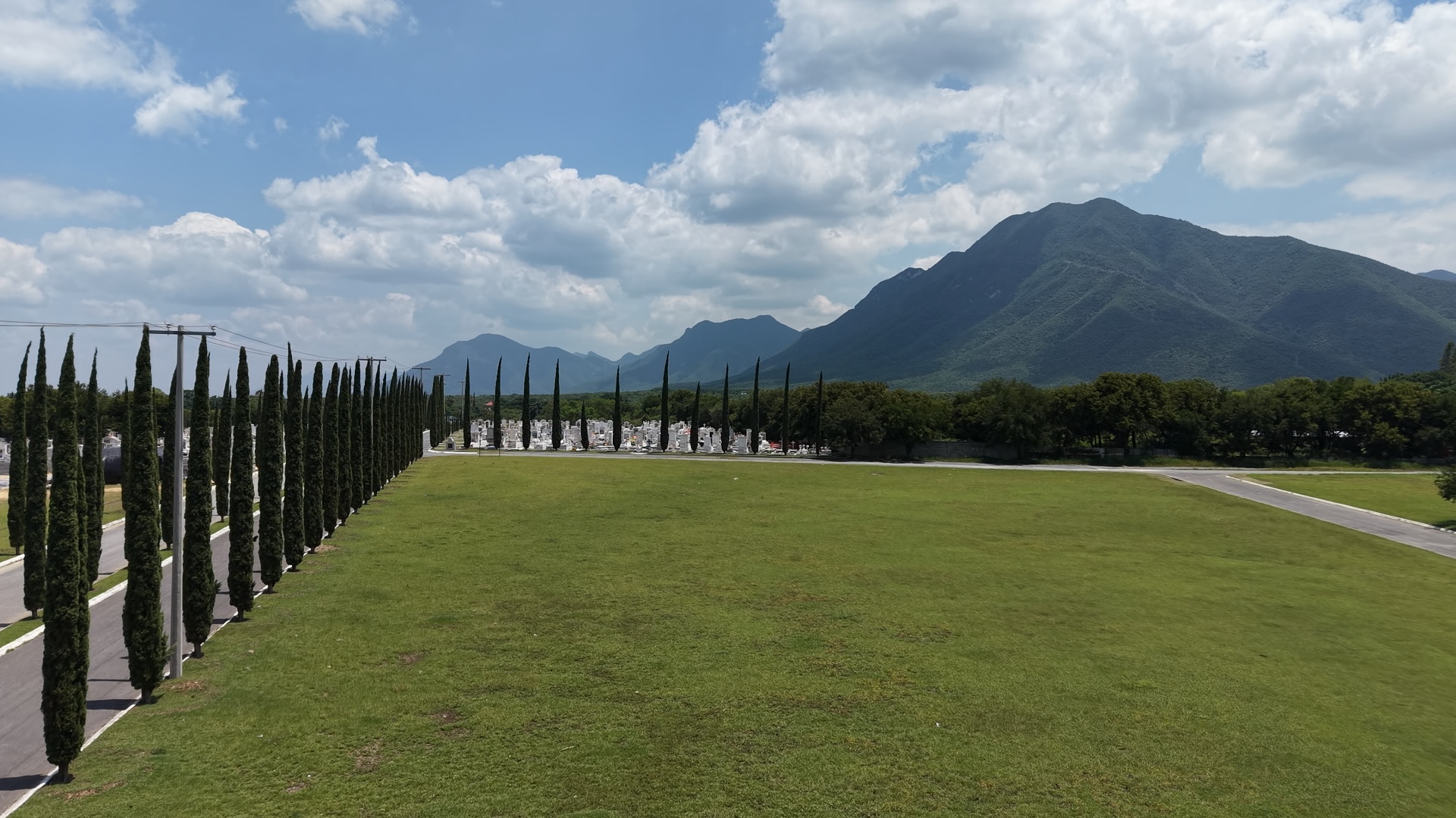 Vista aérea de Jardines de la Sierra, con cipreses, jardines y la Sierra de Juárez al fondo
