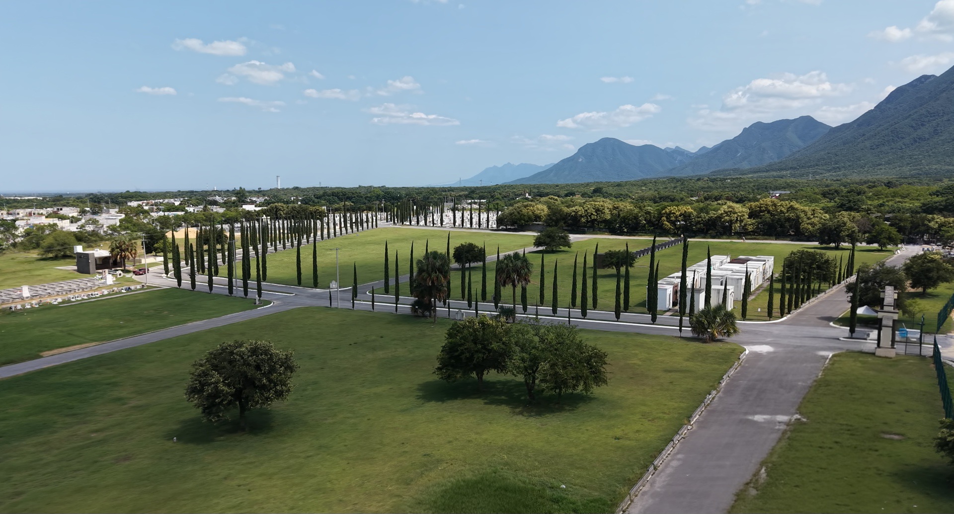 Jardines del parque con cipreses y la Sierra Madre